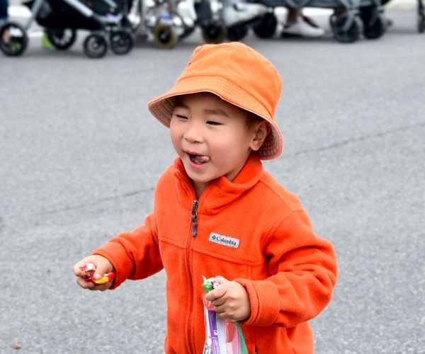 Young boy in orange.